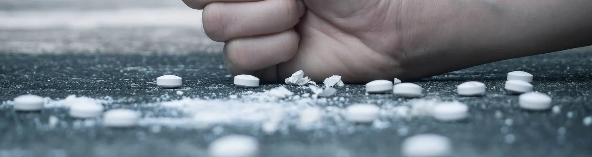 Hand clenched into a fist crushing a lot of pills