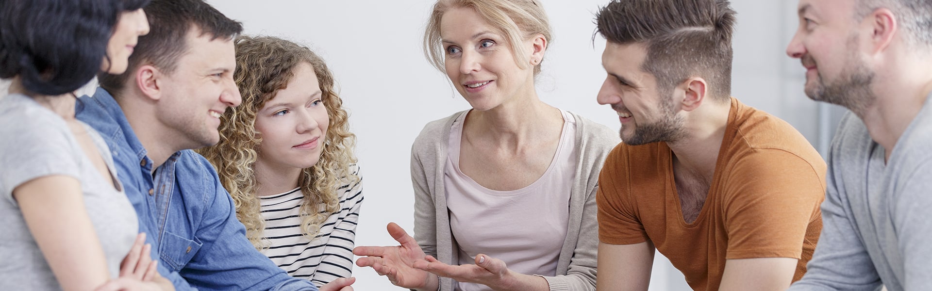 Faces of different aged people, men and women talking in a supportive manner