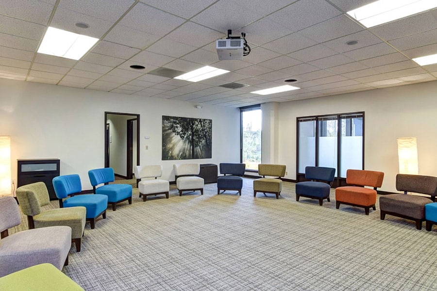 Large, modern room with many chairs in a half circle for group therapy 