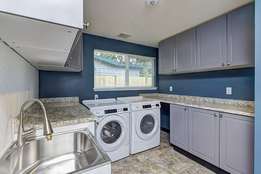 Laundry room with washer and dryer, sink located in our inpatient rehab in Bellevue Washington