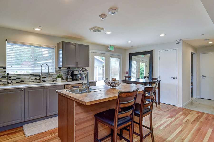 Modern dining room in inpatient rehab with sink, dining table, wood floors, and counters