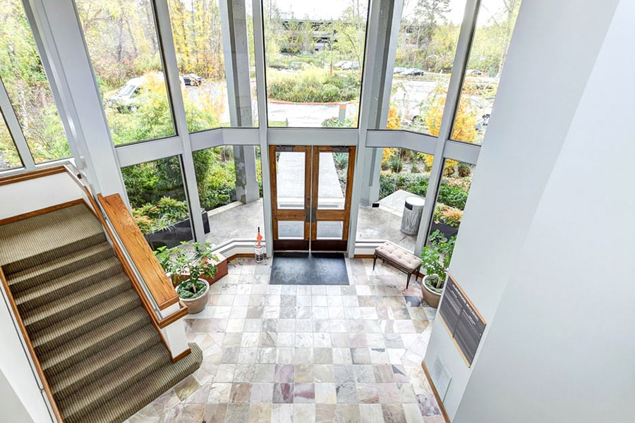 Door entrance from the inside with big windows for light and lots of greenery