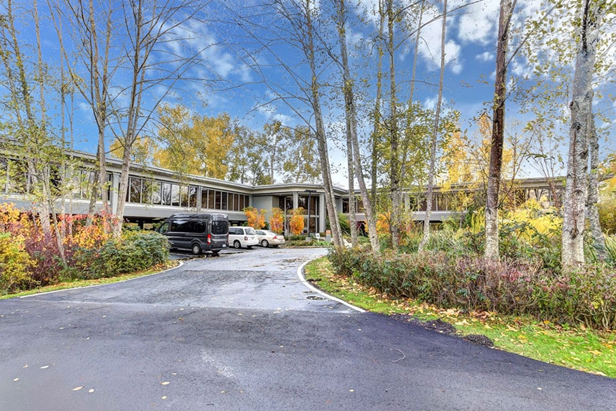 Drive way into Hotel California by the Sea's rehab facility in Bellevue, Washington. With fall colored trees and blue skies 