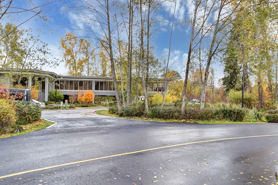 Street in front of Hotel California by the Sea's rehab facility in Bellevue, Washington. With fall colored trees and blue skies 