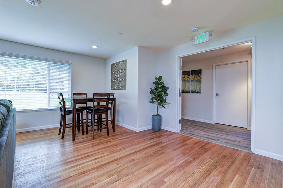 Modern dining room in inpatient rehab with sink, dining table, wood floors, and counters
