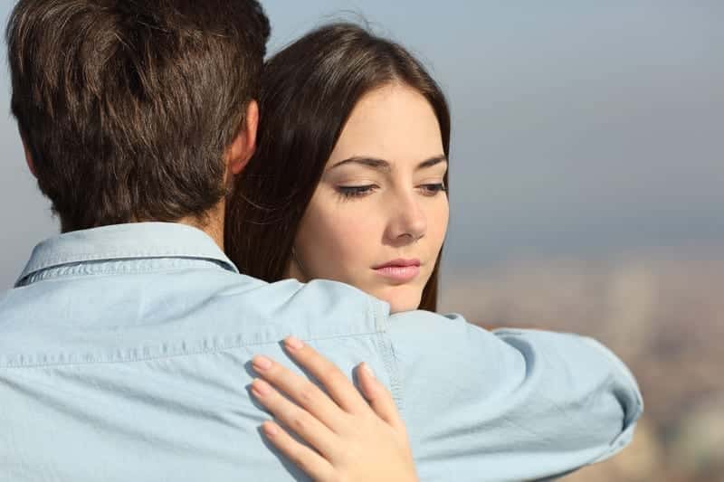 A couple in recovery embraces as they deal with symptoms and indicators of being in a codependent relationship. 