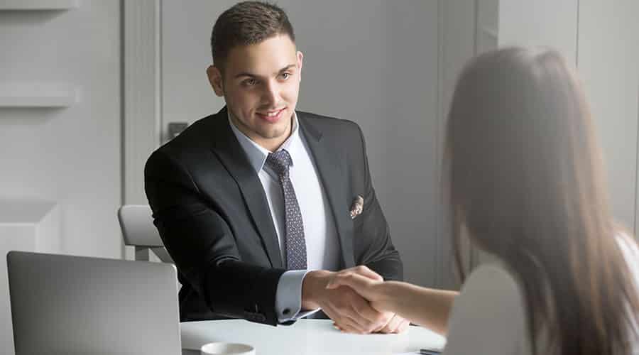 A man shakes hands with a businesswoman as he gets a job after leaving prison and seeking help for drug addiction.