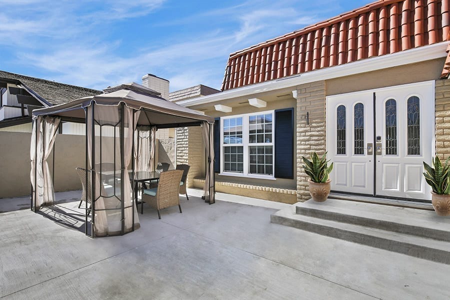 Exterior of california style house with patio furniture and white doors