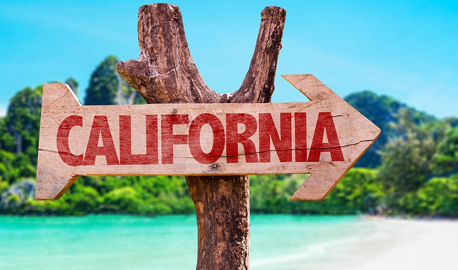 A background of a tropical beach with a wooden sign saying California. 