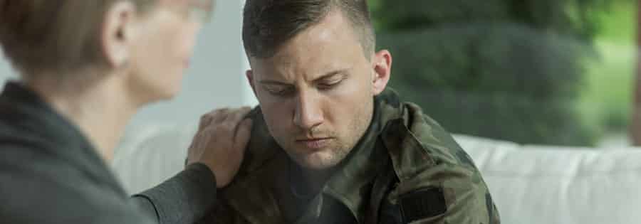 A male military service member looking concerned during a therapy session in substance abuse treatment. 