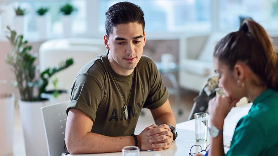 A military man speaks with a professional about his Tricare insurance coverage of substance abuse treatment. 