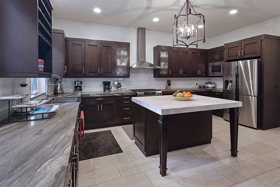 kitchen at Hotel California by the Sea's inpatient rehab home. With dark wood cabinets, modern fixtures, and bright lighting
