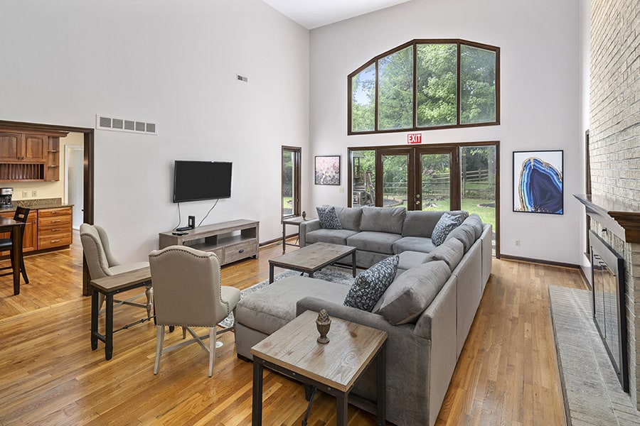 Living room with grey sectional and wood floors, large windows in our residential rehab in Cincinnati