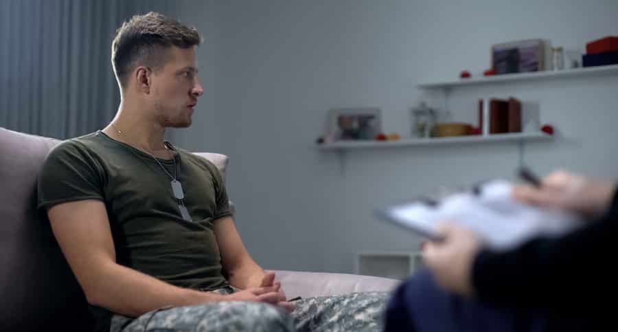 A male veteran is speaking to a professional about his struggles with PTSD and addiction and their connection to each other. 
