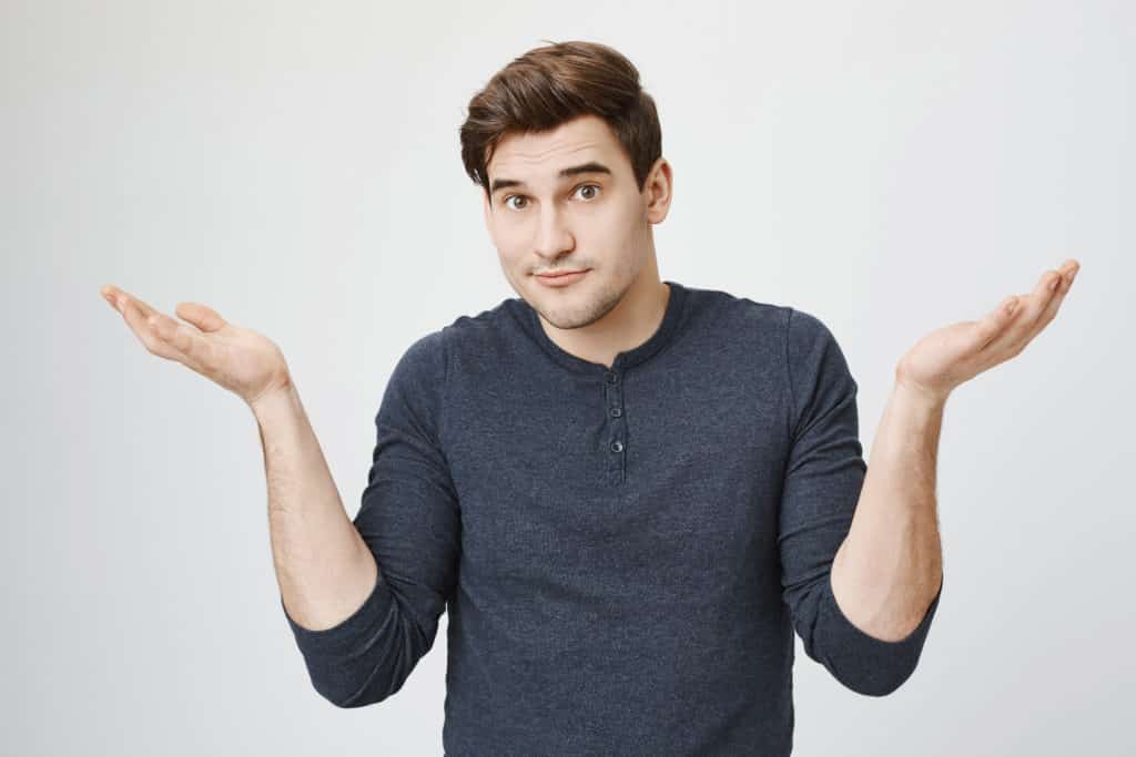 Young man in grey shirt shrugging, not knowing if he has anthem blue cross substance abuse coverage