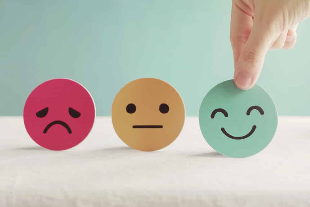 Three emoji faces: a red sad face, a yellow indifferent face and a green smiling face. 