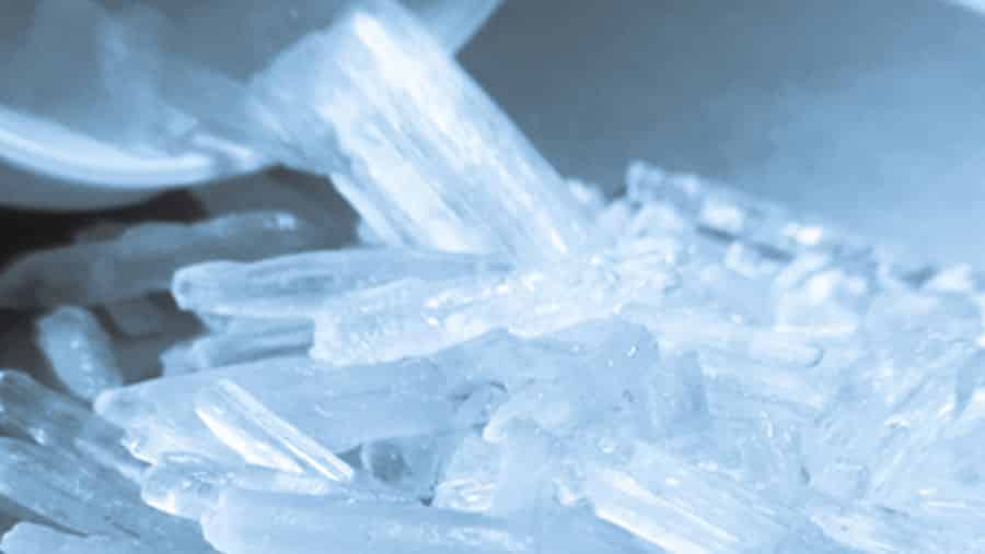 An image of a solid form of crystal meth represents how to tell if someone is on meth, what is meth and how to get off meth. 
