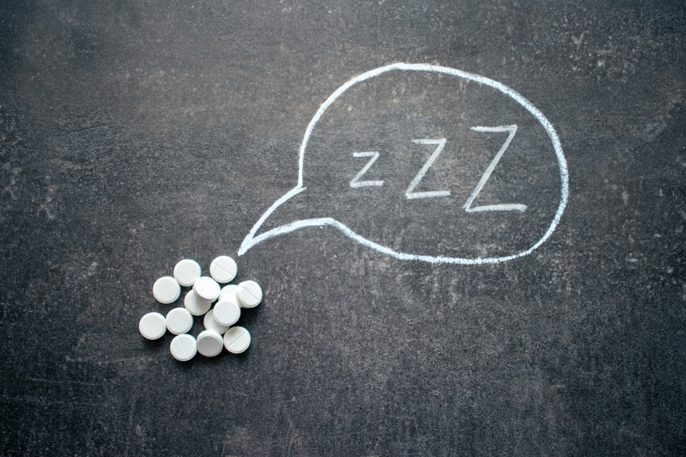 White sleeping pills on a chalkboard with a thought bubble drawn out from them  with "ZZZ" insides