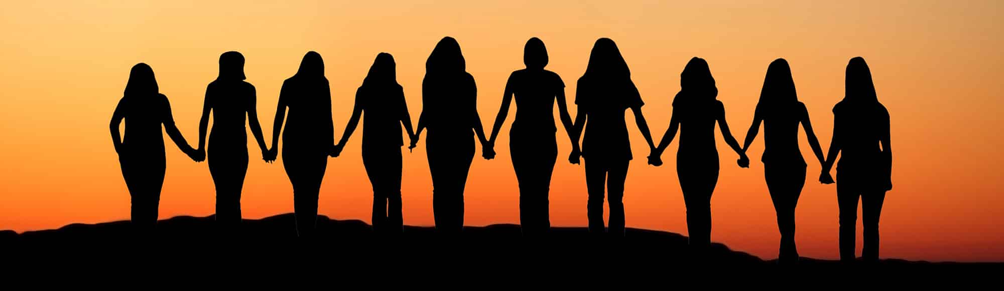 Black profiles of many women holding hands in a line with orange gradient colors behind them