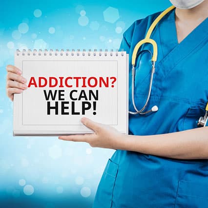 Woman in scrubs with stethoscope  holding a sign that says "addiction? we can help!"