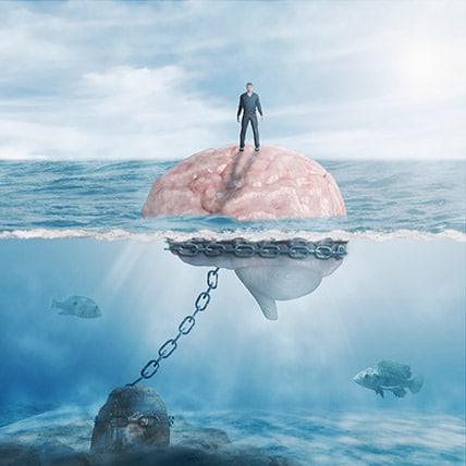 Man floating on brain in the middle of the ocean, there's a chain attached to the brain holding it in the same spot