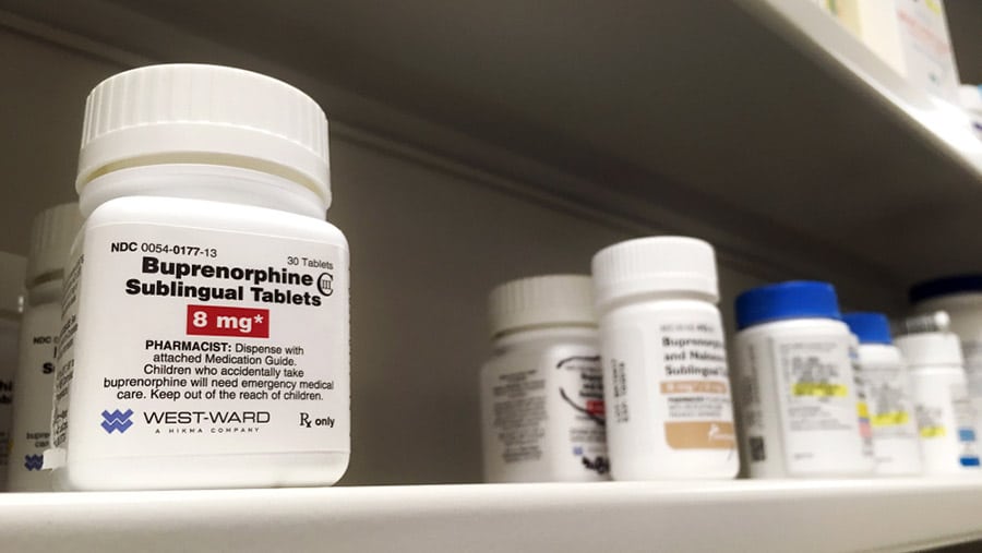 A pharmaceutical shelf containing various prescription medications for Subutex withdrawal including a bottle of buprenorphine sublingual tablets. 