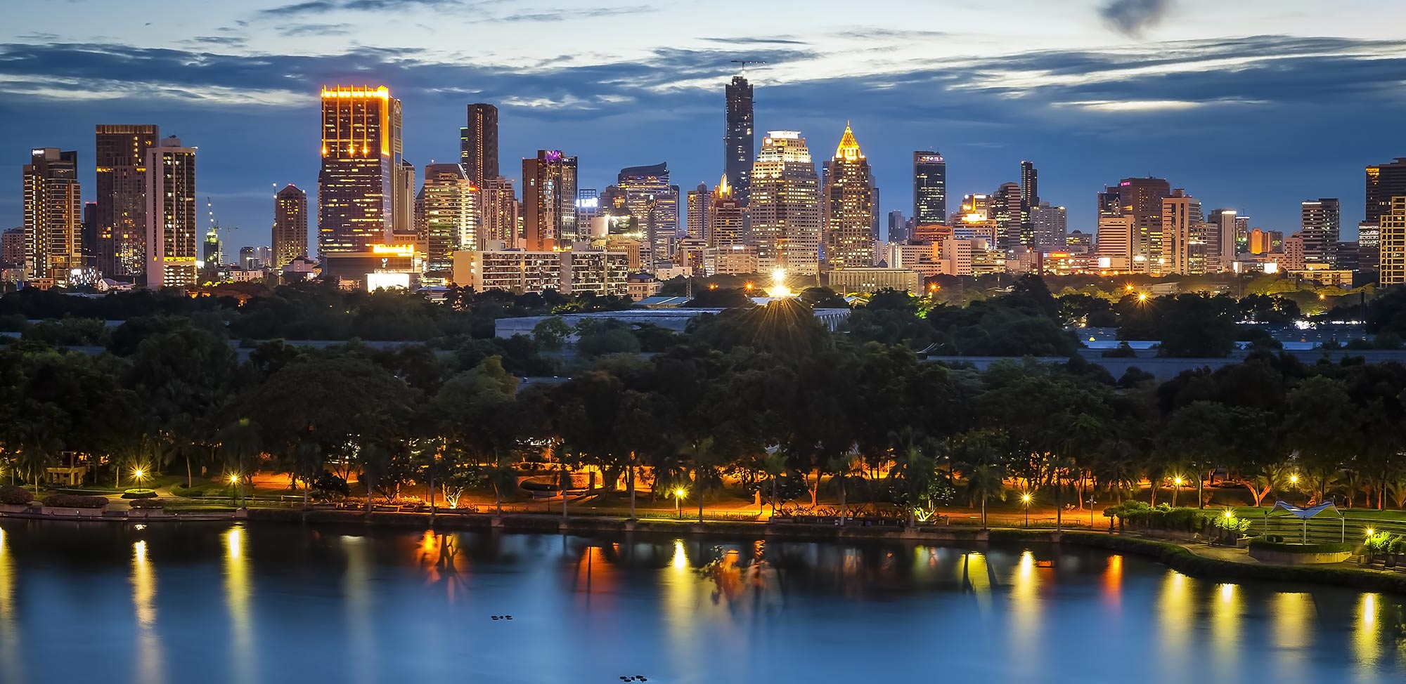 Skyline of Bellevue Washington with lit night skies, bright lit buildings and lake water reflecting back the light from the buildings in the forefront