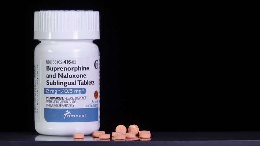 A white bottle of Buprenorphine and Naloxone with orange pills laid out questions if anxiety meds can be taken with Suboxone. 