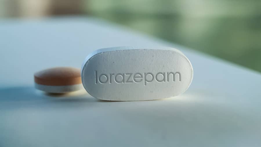 A white lorazepam tablet sits on a white table begs the question: is lorazepam addictive? 