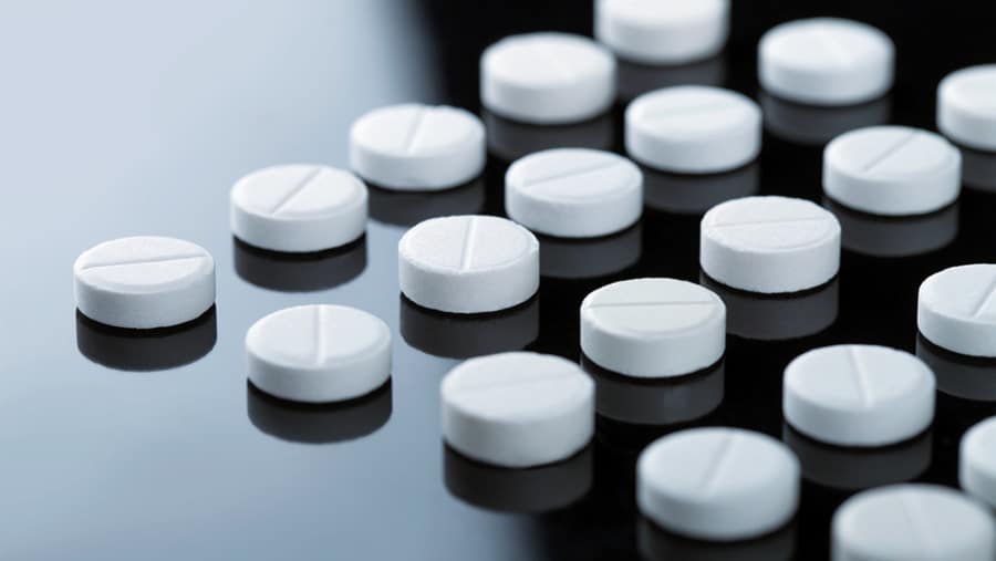 White circular Valium tablets lined up in rows on a black table begs the question, is Valium addictive?