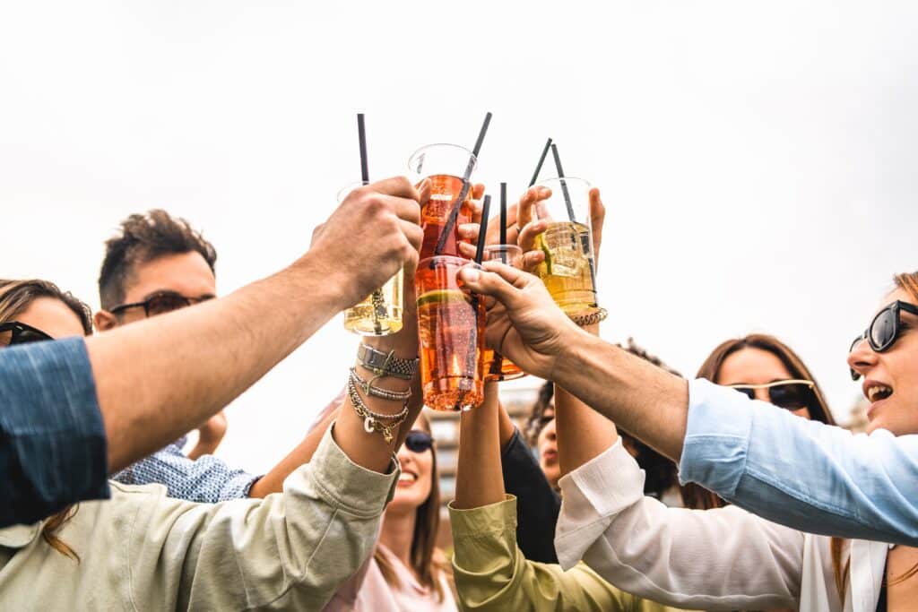 A group of young people are in a circle raising their glasses of alcohol together wonders how to flush alcohol from their urine after a drinking.