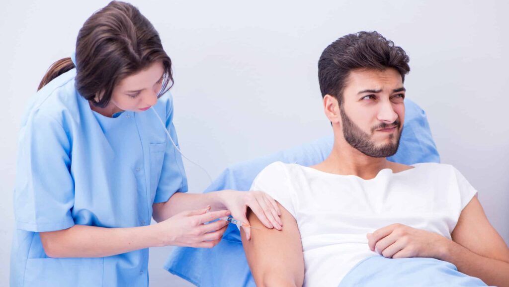 A young man in opioid addiction treatment receiving injection of either Sublocade or Vivitrol by a female clinician.