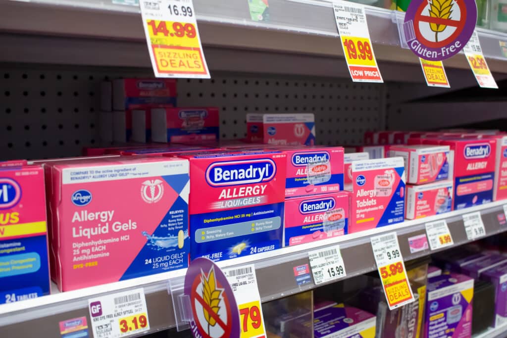 A row of Benadryl and other allergy medications on a store shelf makes users question is Benadryl addictive?