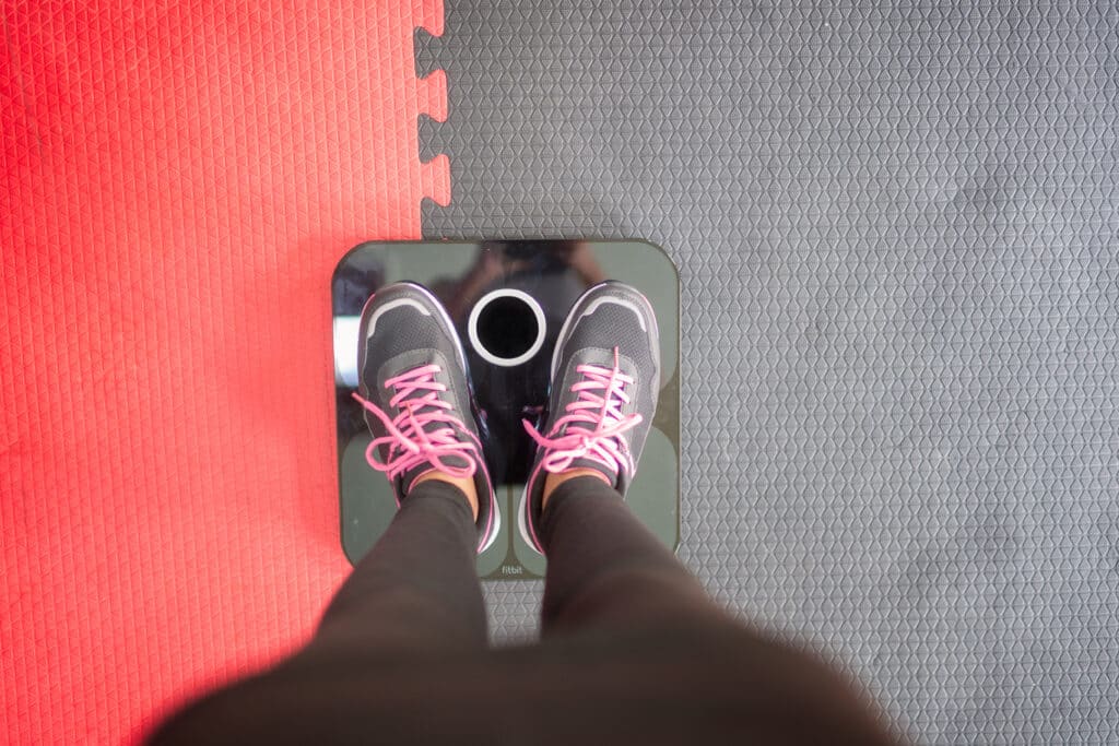 A person stands on a scale at the gym and questions whether or not Xanax causes weight gain.