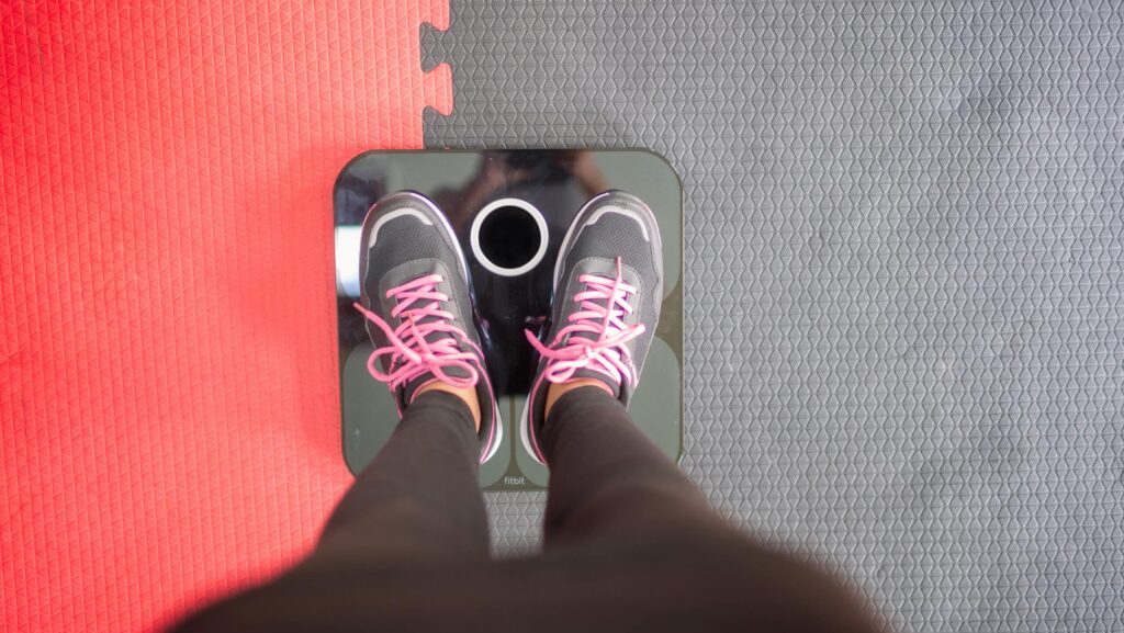 A person stands on a scale at the gym and questions whether or not Xanax causes weight gain.