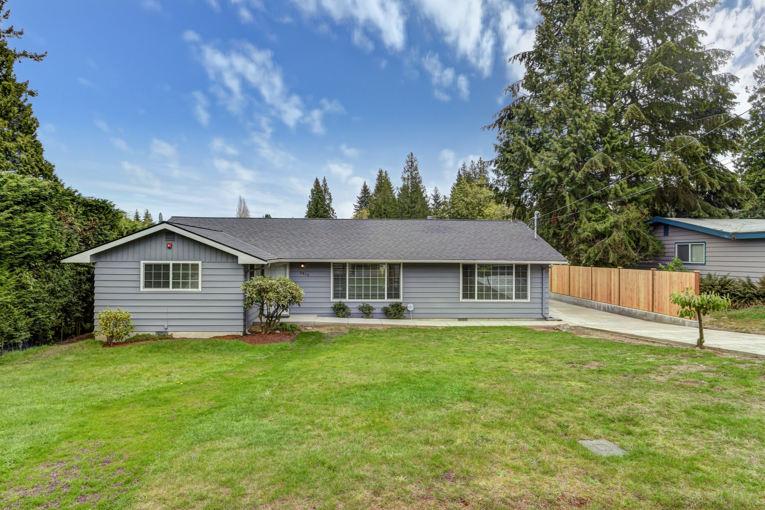 Front of alcohol rehab in washington state with gray roof, gray walls, and large green field in front.