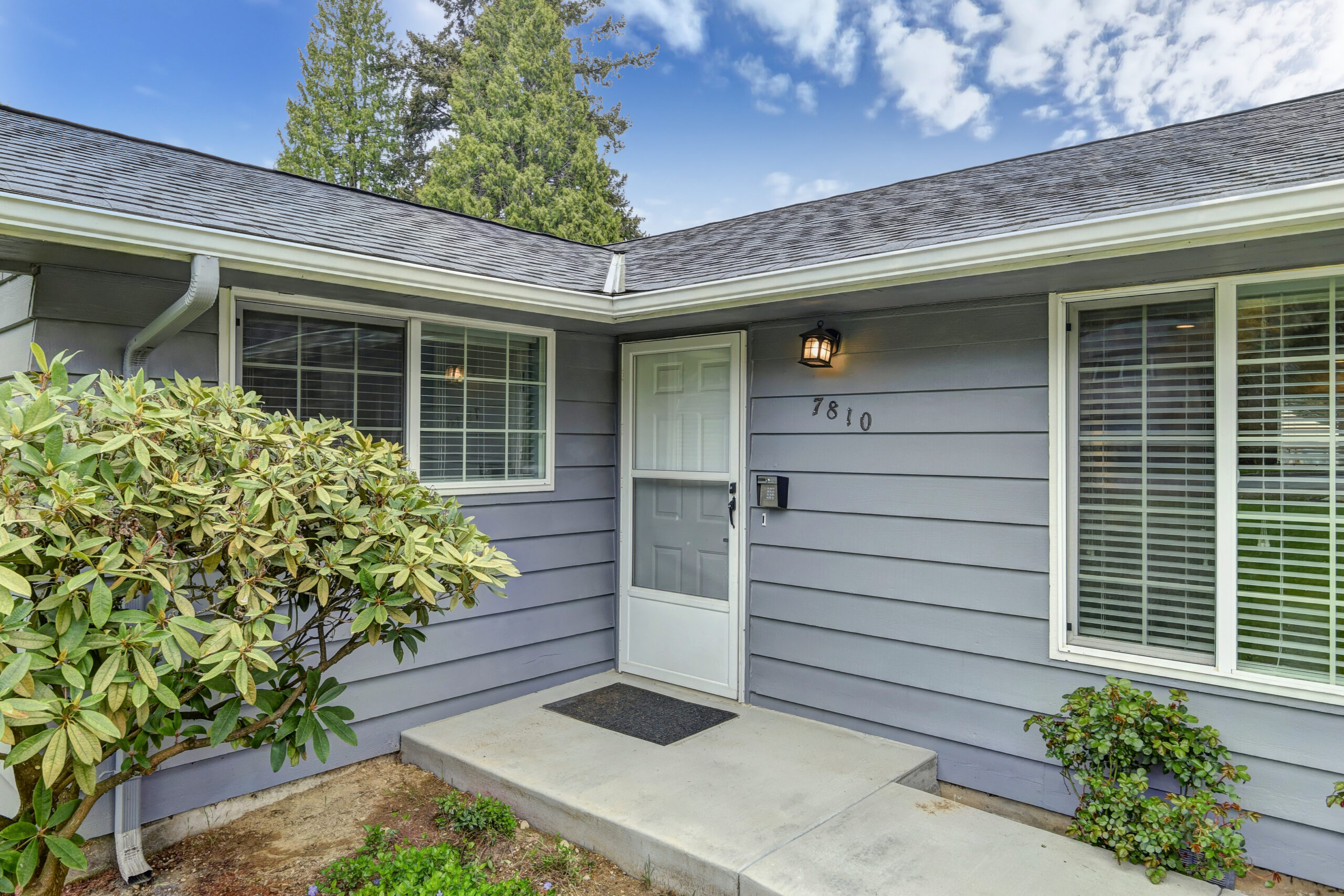 Front of house with white door and gray walls, two windows at washington state prescription drug program