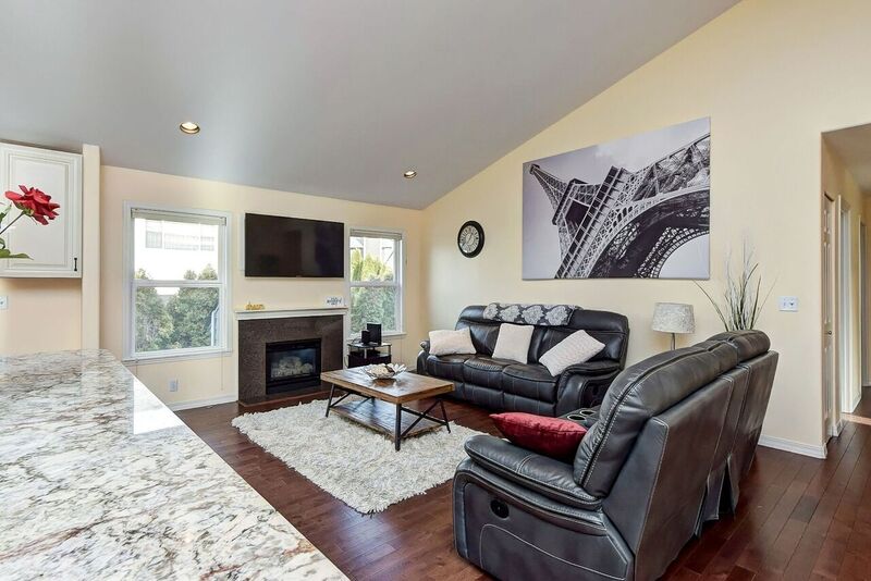 Living room of intensive outpatient rehab in seattle with gray couches, coffee table, and picture of eiffel tower