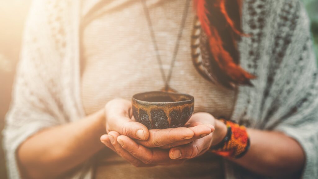 A female is holding a small bowl with both hands containing the psychoactive substance DMT, which begs the question of how long does DMT last?
