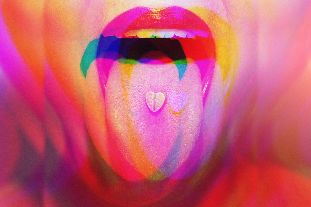 A woman with an ecstasy pill on her tongue represents the popularity of the drug and can you snort ecstasy.