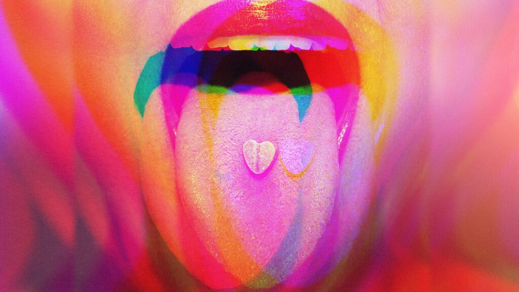 A woman with an ecstasy pill on her tongue represents the popularity of the drug and can you snort ecstasy.