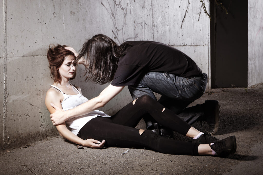 A young girl nodding off after opioid use and her male friend checking up on her to make sure she is ok.