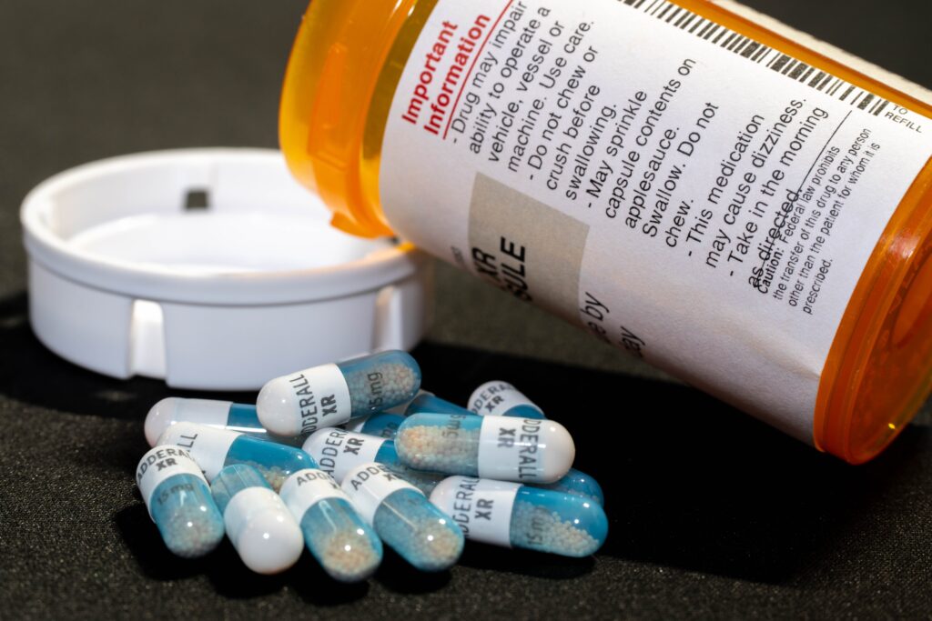 A prescription bottle of a popular amphetamine Adderall XR represents amphetamine use signs.