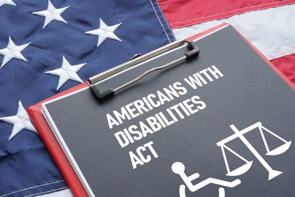 An American flag behind a clipboard of the Americans with Disabilities Act questioning if addiction is a disability.