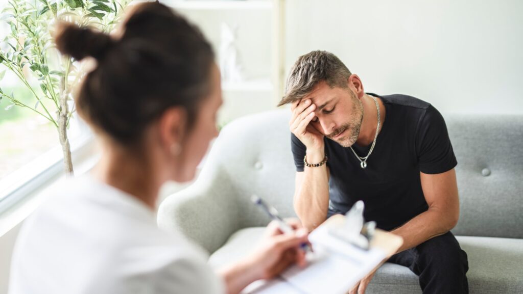 A young male addict speaking with a female profession represents one way in how to support an addict.