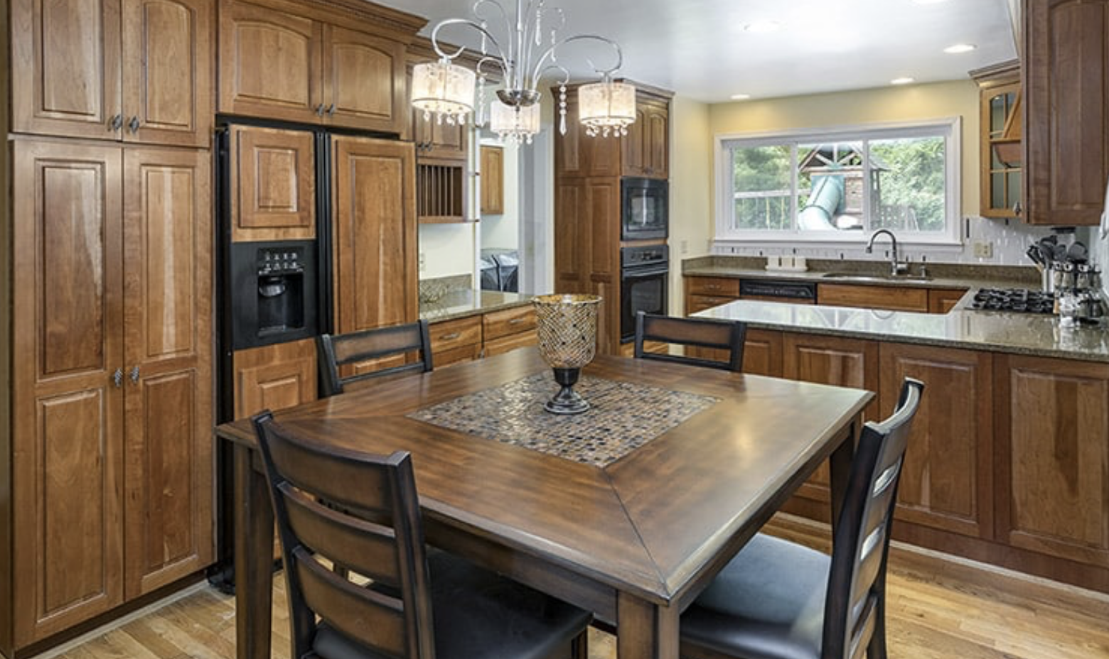 Beautiful bright lit kitchen, wood table, cabinets, and sink. Modern and clean