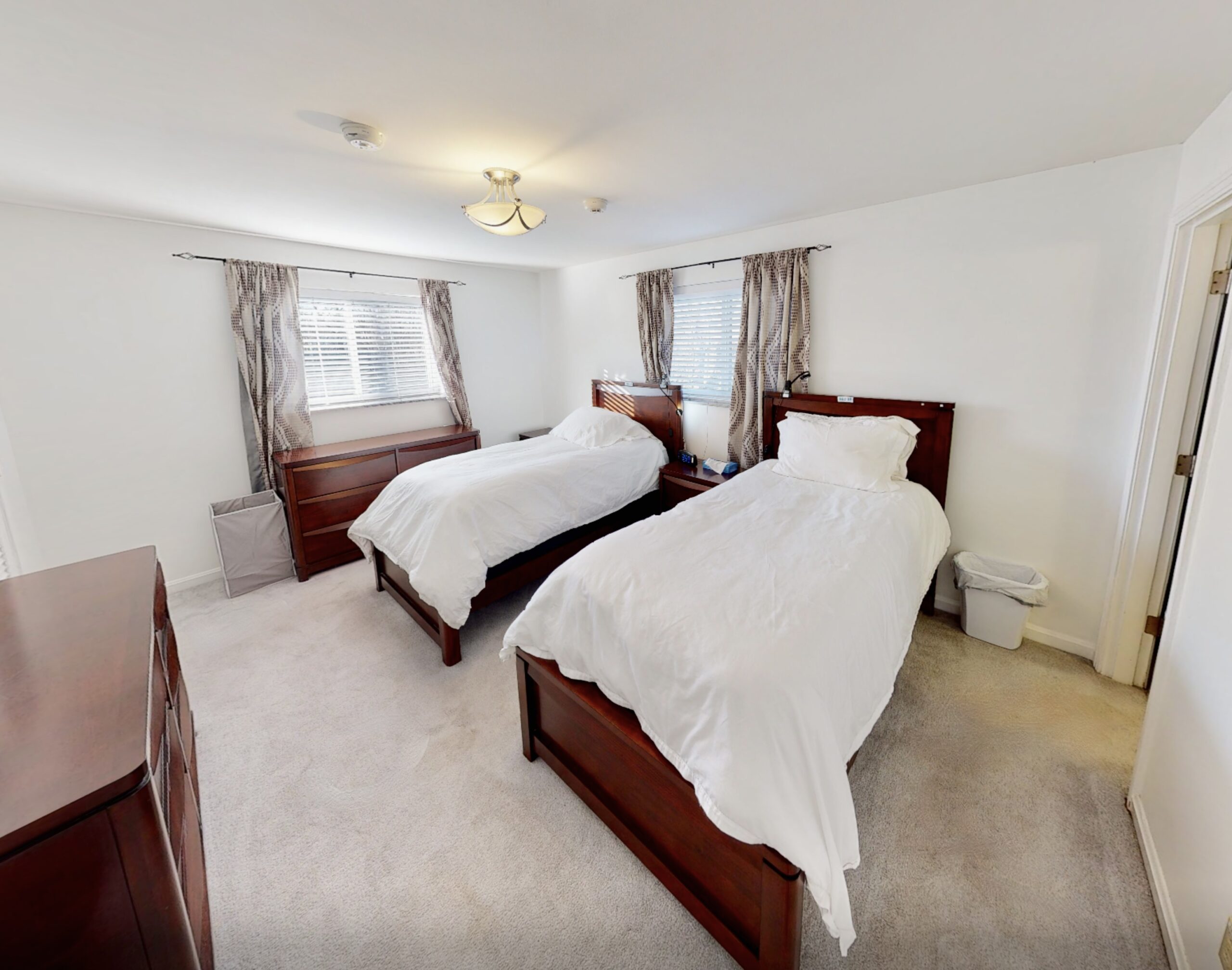 Clean, bright lit room with two beds, clean linens, white carpet