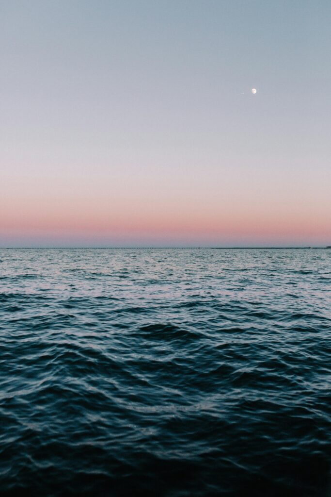 Tranquil twilight sea view with calming waves and pastel sky hues.