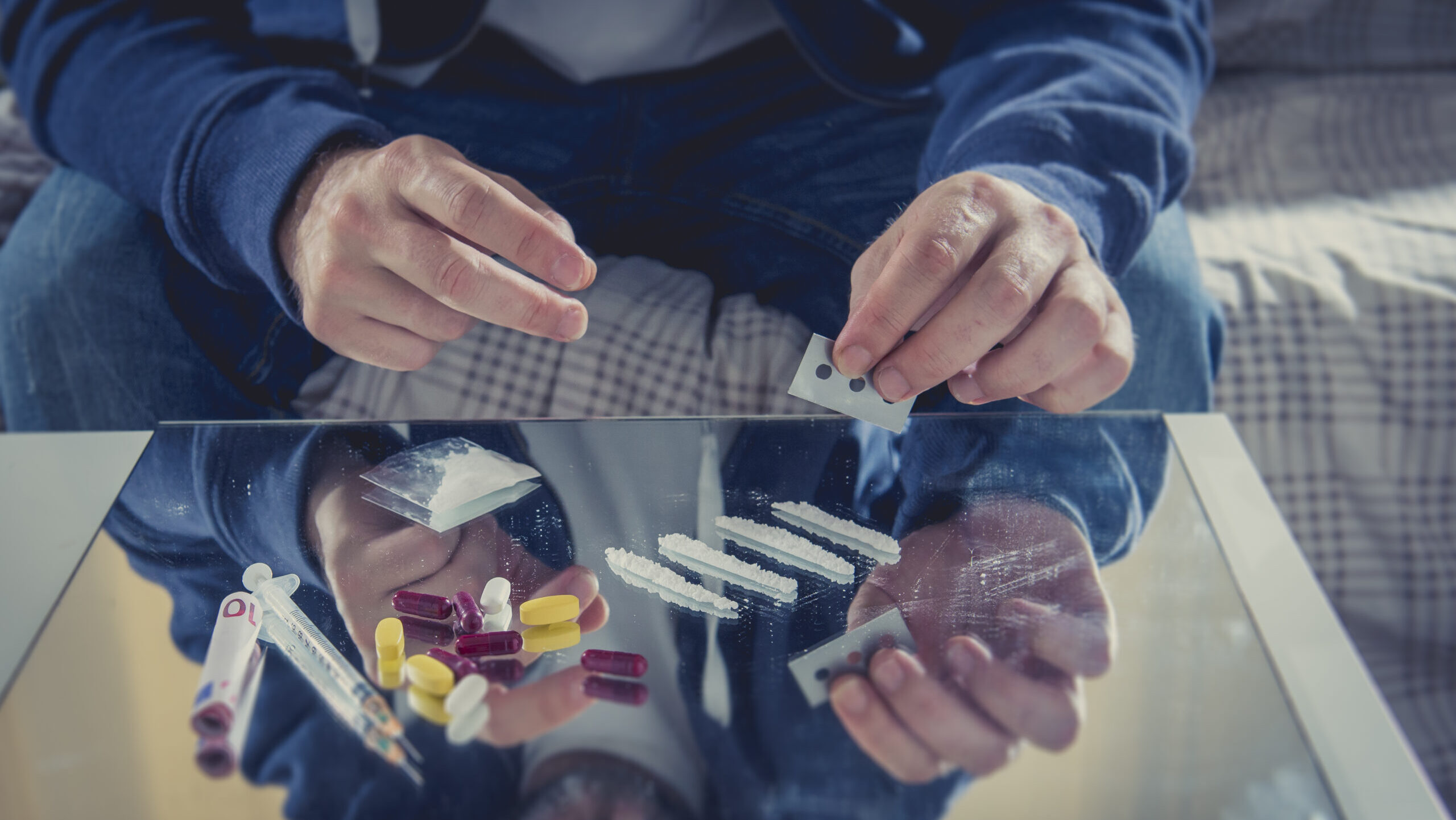 A person snorting lines of heroin with a rolled up bill.