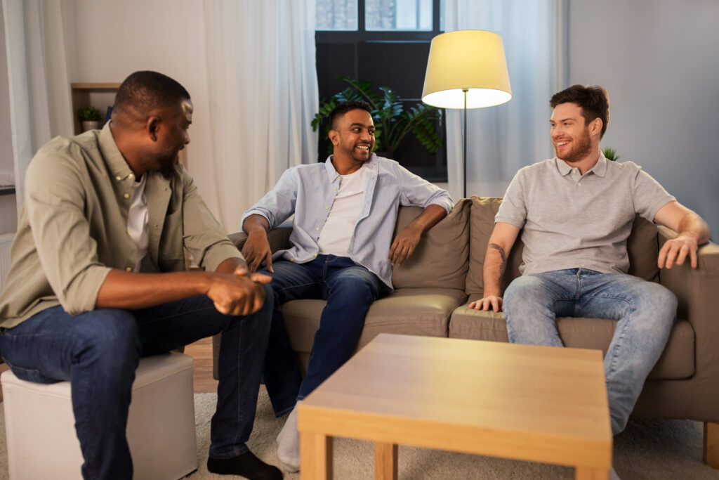 A group of young males sitting in living room of detox and residential treatment facility.